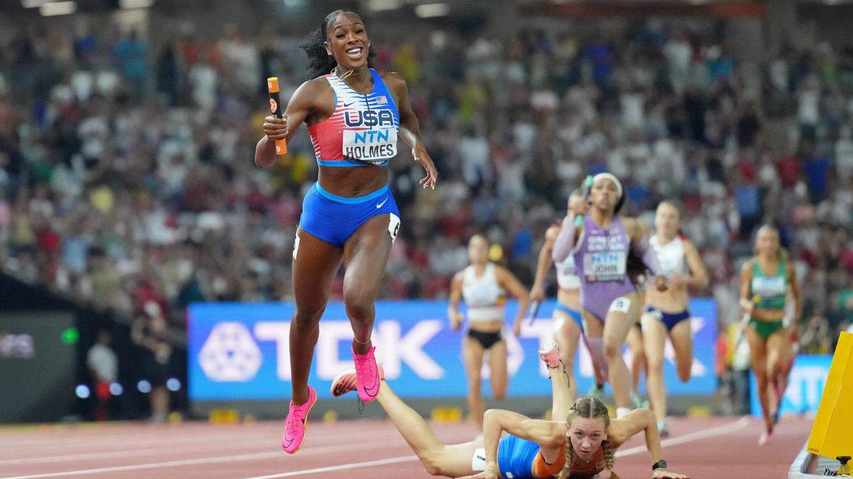 Former Kentucky track standout Alexis Holmes (foreground) won a stirring stretch duel with Dutch star Femke Bol (fallen) to give Team USA the gold medal in world-record time in the 4x400 mixed relay in the World Athletics Championships Saturday in Budapest, Hungary.