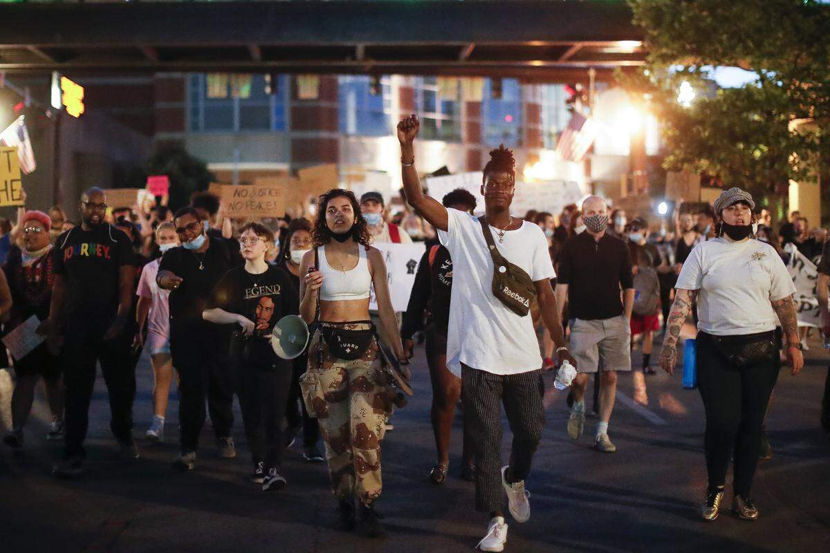 Alivia Keseday, left, and Phillip Manga, both of Lexington, Ky., march along West Vine Street during the fifth night of protests in downtown Lexington, Ky., Tuesday, June 2, 2020. The protests come amid a nationwide outcry over the deaths of George Floyd in Minneapolis and Breonna Taylor in Louisville.