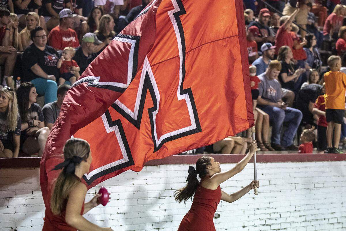 Mayfield cheerleader Julissa Ramirez, right, a senior, runs with the Mayfield flag after the Cardinals scored in the second half.