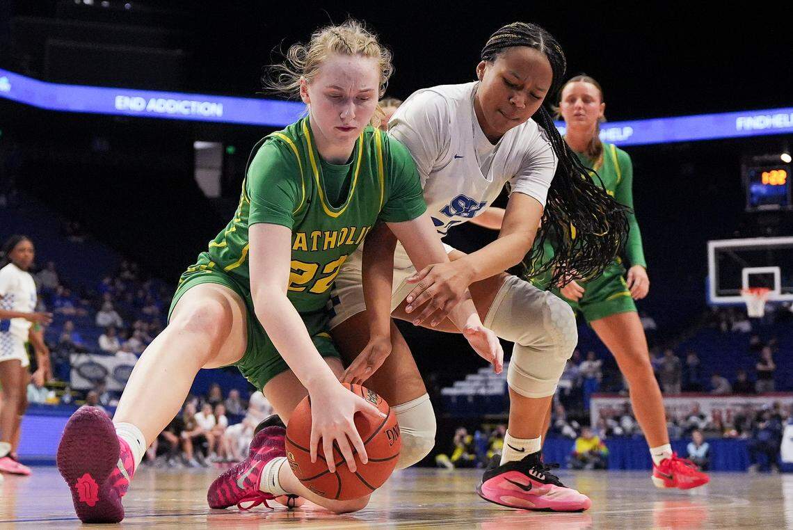 Owensboro Catholic's Sophia Newby (22) and Simon Kenton’s Haylie Webb go for a loose ball under the basket during the Clark’s Pump-N-Shop Girls’ Basketball Sweet 16 quarterfinals at Rupp Arena on Friday.