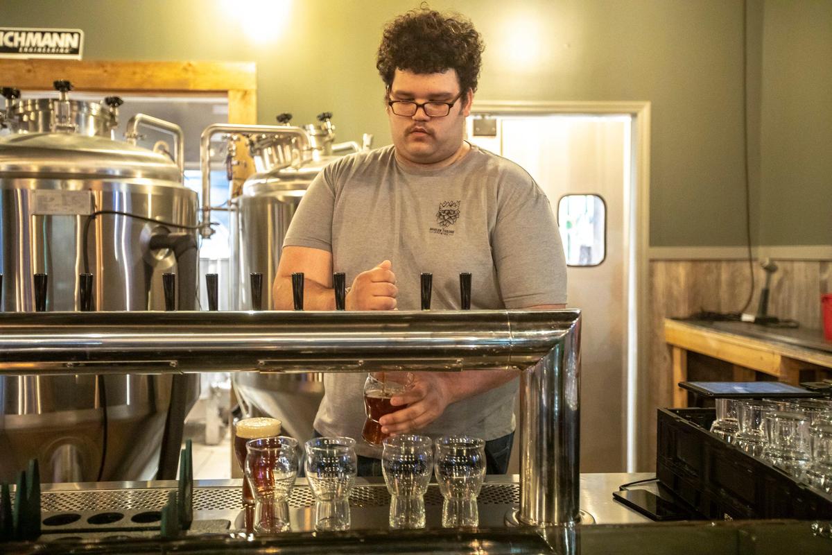 Beertender Demitrius Peaby pours a beer at Broken Throne Brewing.