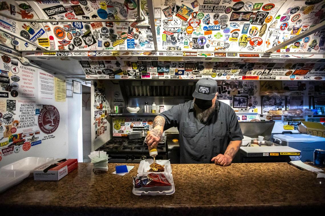 John Dale Warner, putting the finishing touches on a bacon bleu burger, opened Wink’s Bar in 2014 after a road trip out west.