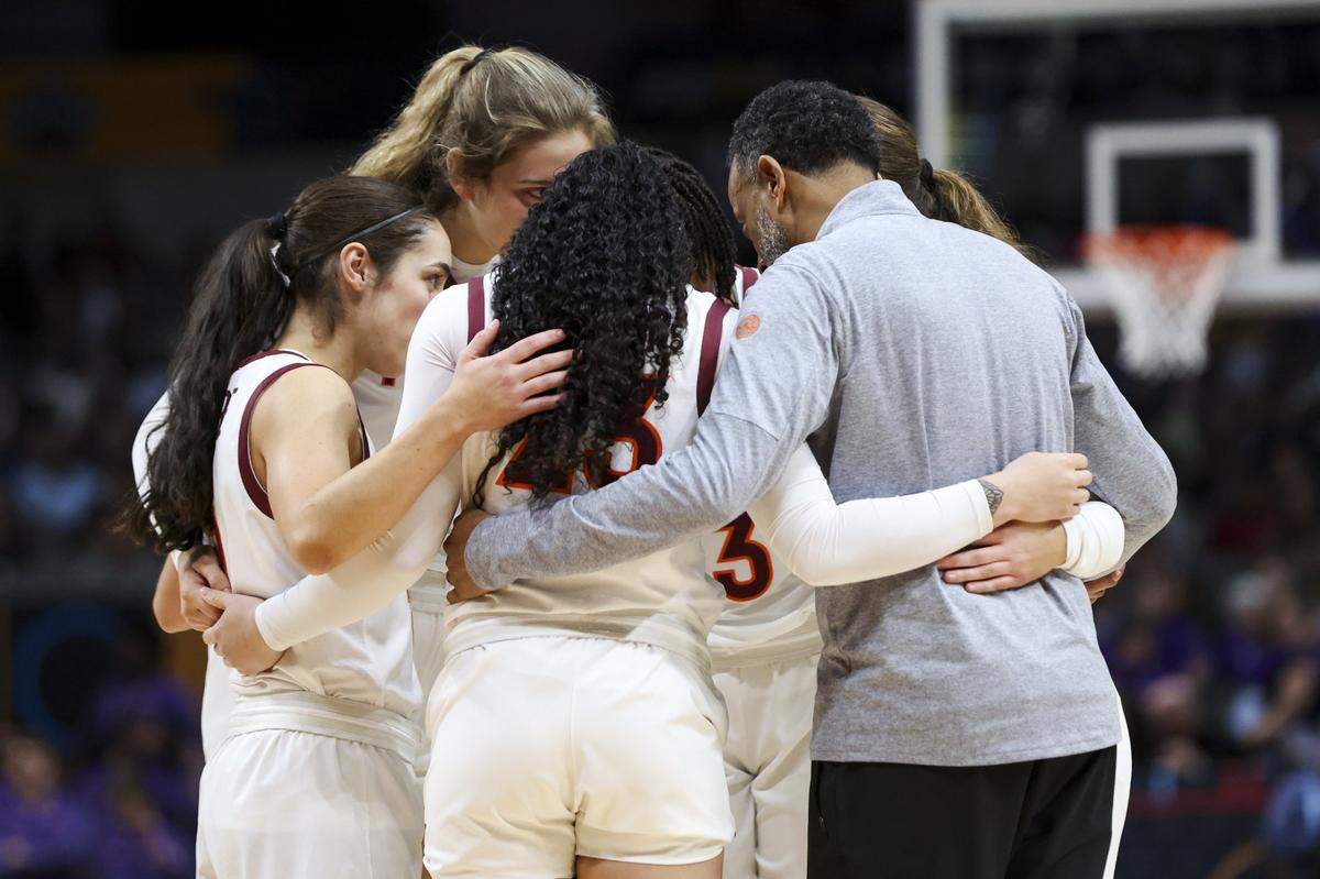 Kenny Brooks, right, stood in a team huddle prior to coaching Virginia Tech against LSU in last season’s Final Four. The Hokies took a nine-point lead into the fourth quarter, but fell to eventual national champion LSU 79-72.
