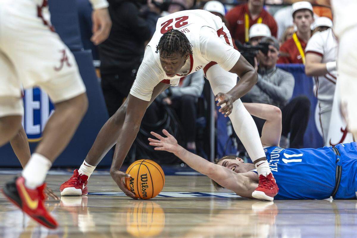 Kentucky guard Travis Perry (11) reaches for a loose ball as Alabama forward Aiden Sherrell (22) picks it up during Friday’s SEC Tournament game at Bridgestone Arena in Nashville, Tennessee.