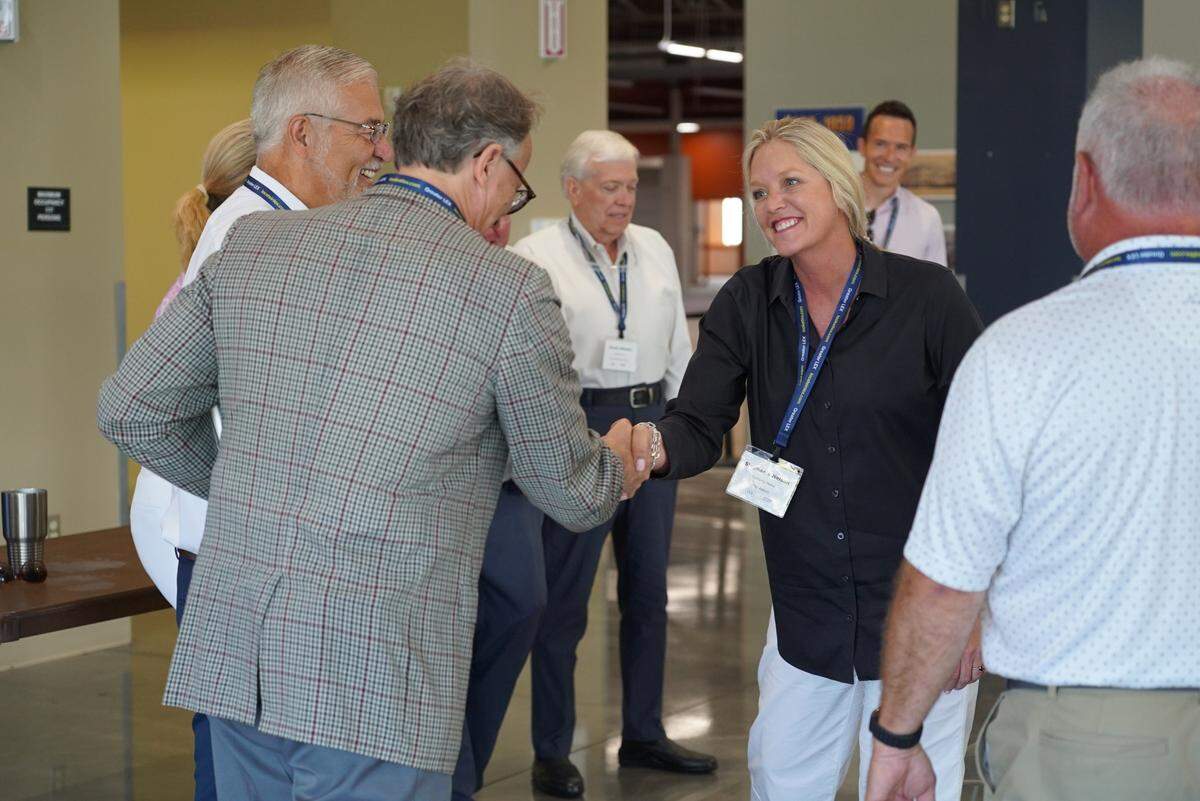 U.S. Sen. Mitch McConnell’s field representative Stephanie Nelson shakes hands with another community leader during an economic development simulation hosted by Commerce Lexington Monday, June 23, 2025, at the Bluegrass Community & Technical College Winchester - Clark County campus.