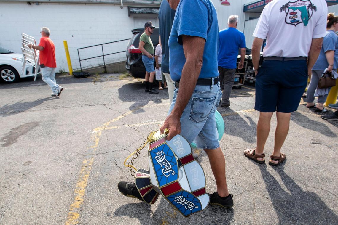 Patrons buy fixtures, menus and merchandise from Parkette Drive-In during a sale in Lexington, Ky., Saturday, July 23, 2022.