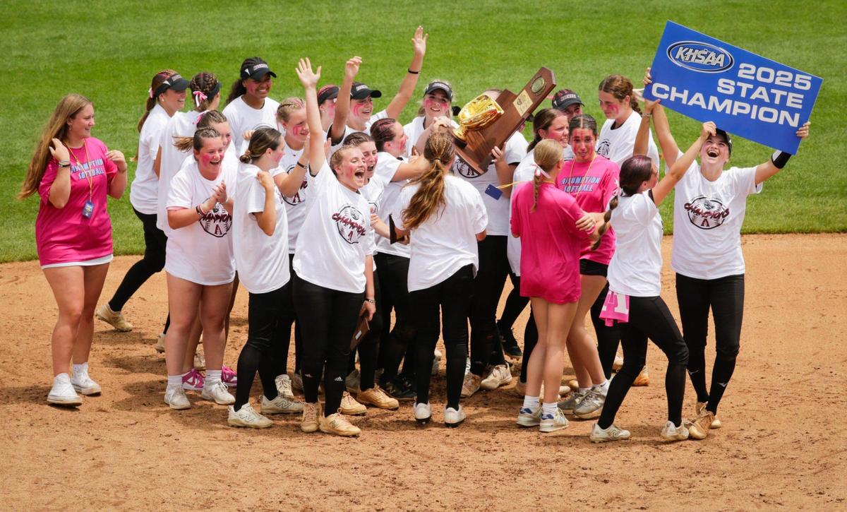 Assumption players celebrated after being awarded the championship trophy following their 4-2 win over Henderson County in the KHSAA state softball tournament finals at the University of Kentucky’s John Cropp Stadium on Saturday.