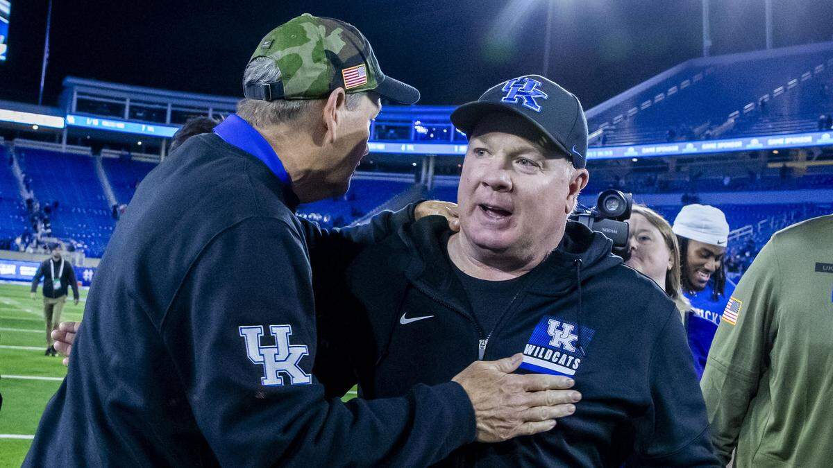 Kentucky football coach Mark Stoops, right, got congratulations from UK athletics director Mitch Barnhart after the Wildcats trounced Florida 38-7 Saturday night at Kroger Field.