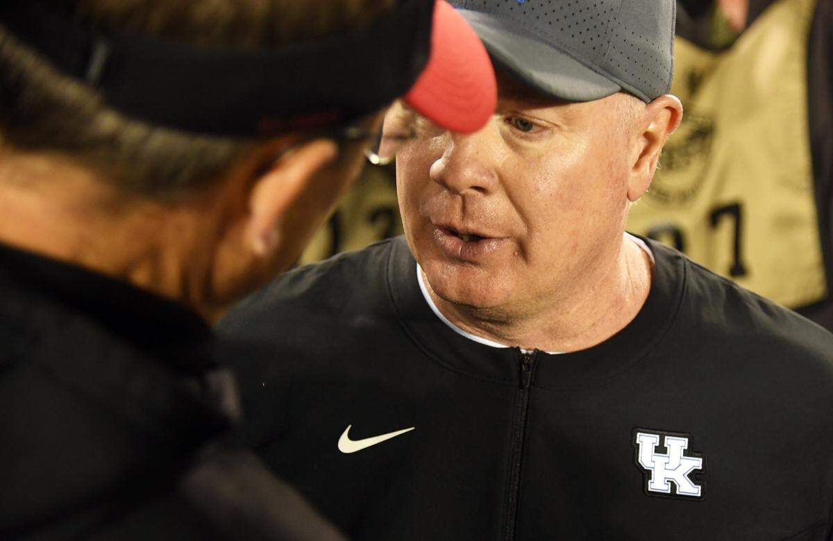 Kentucky coach Mark Stoops, right, greeted Louisville head man Scott Satterfield, left, after UK’s 26-13 win over U of L last season at Kroger Field. Subsequent to the defeat, Satterfield left the Cardinals program to become head coach at Cincinnati.