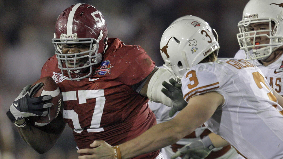 Alabama defensive lineman Marcell Dareus (57) pushes off Texas quarterback Garrett Gilbert (3) after catching an interception during the 2010 BCS Championship in Pasadena, Calif., Jan. 7, 2010. The two teams will meet again in the regular season for the 2022 and 2023 seasons it was announced on Wednesday.