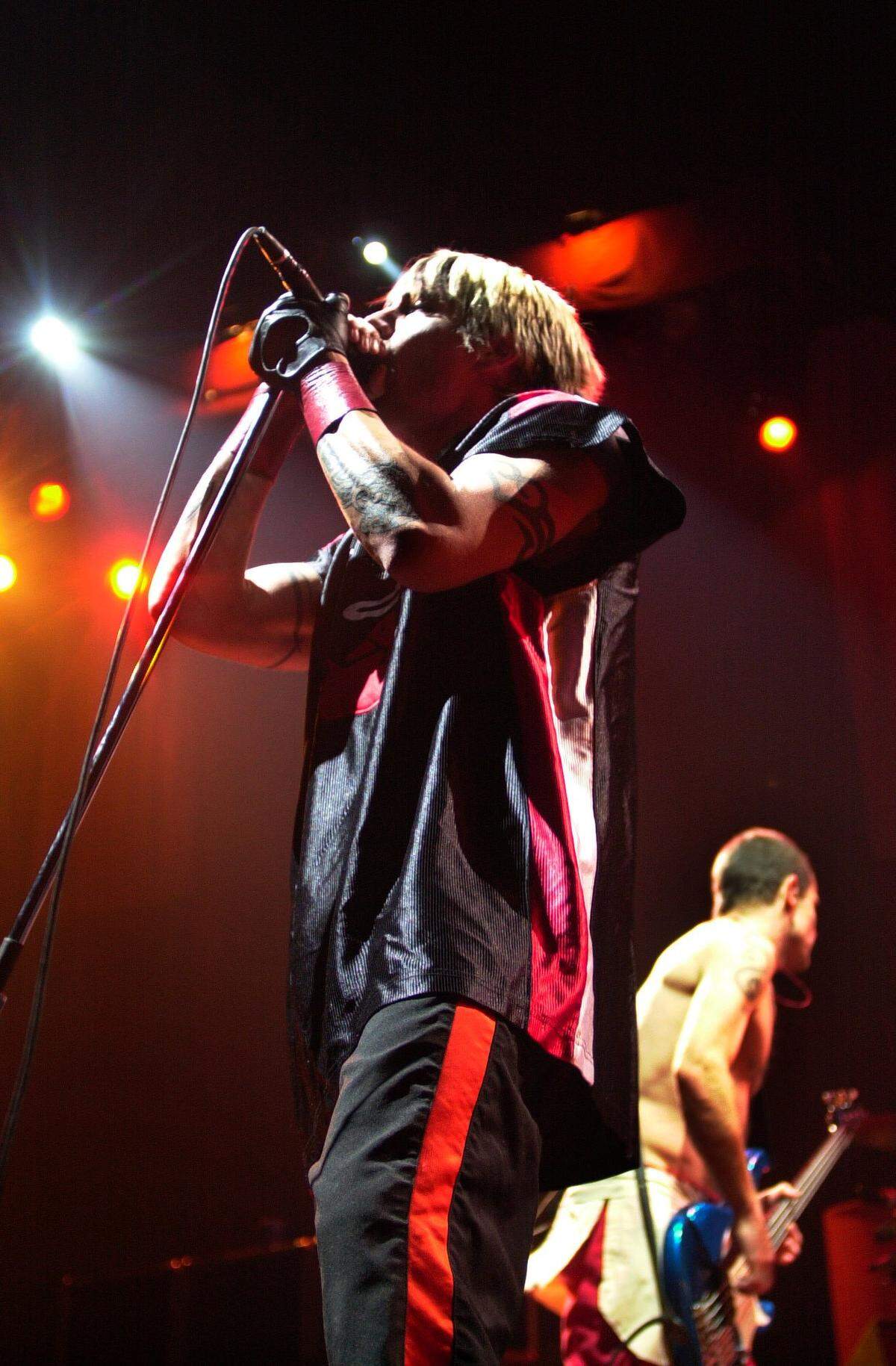 Red Hot Chili Peppers frontman Anthony Kiedis, and Flea, background, brought the Rupp Arena crowd to their feet as they tore into the first song of the night following the Foo Fighters on April 9 , 2000 in Lexington ,Ky.