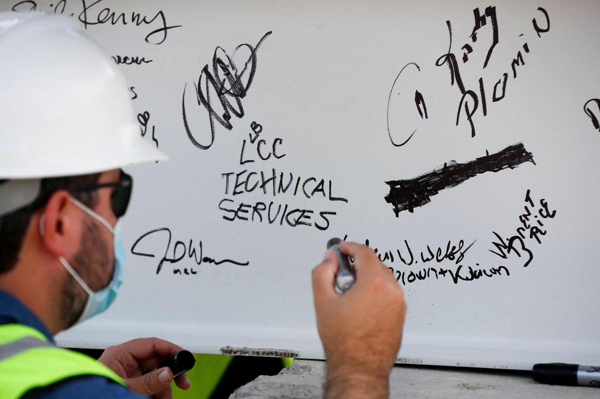 Matthew Weekly, of Lexington, Ky., with Brown + Kubican Structural Engineers, signs the final 15-foot structural steel beam before it is installed atop Central Bank Center in downtown Lexington, Thursday, Sept. 10, 2020.