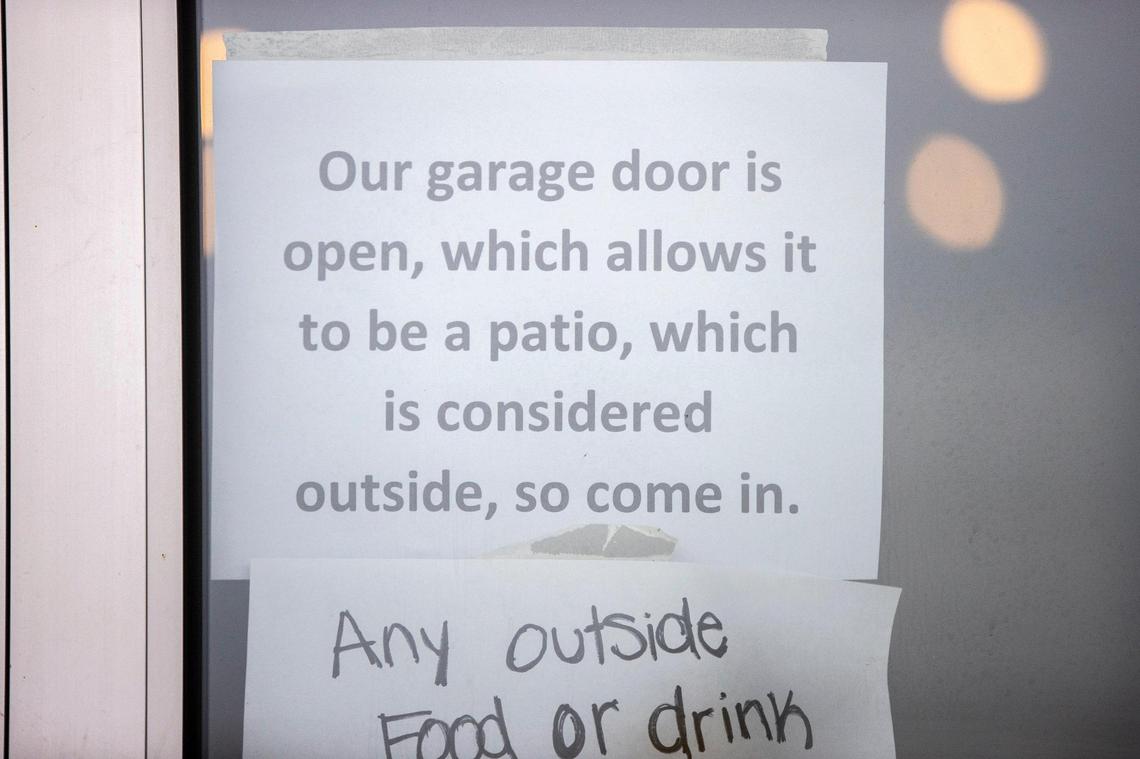A sign posted on the door of Brewed in Lexington, Ky., said said the garage door in the establishment was open, “which allows it to be a patio, which is considered outside, so come in.”