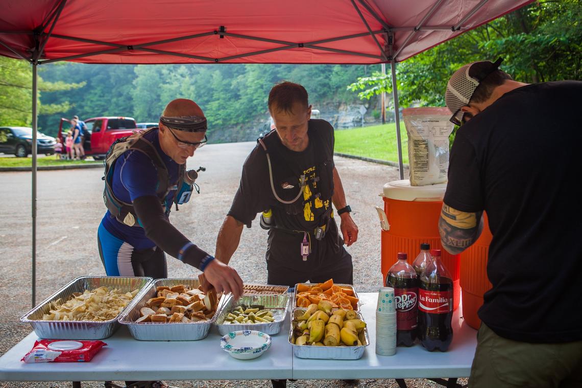Runners stopped at the Natural Bridge aid station at mile 12.7 to grab a bite and rehydrate during the War Hammer 100 Endurance Run last weekend.