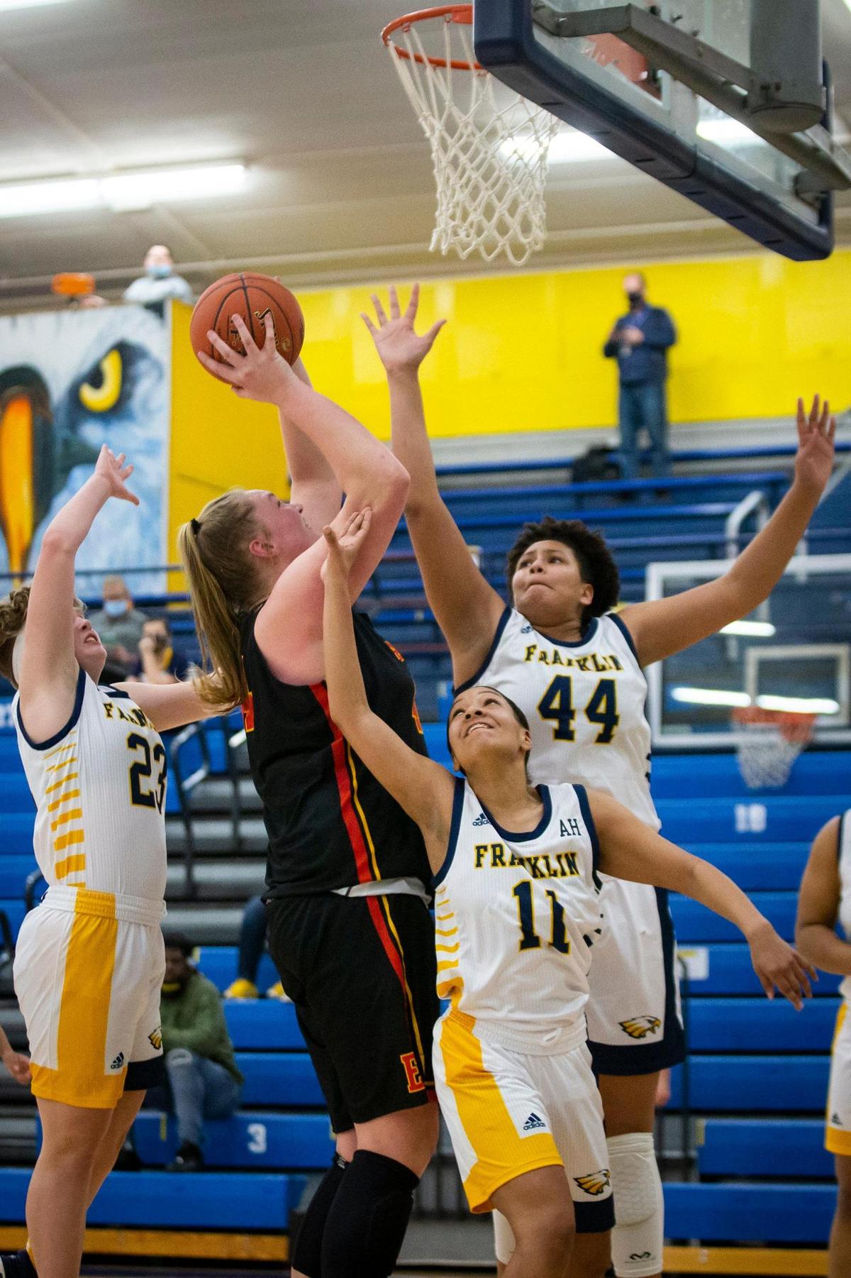 A trio of Franklin County defenders tried to stop Bullitt East’s Gracie Merkle during Monday night’s game in Frankfort. The 6-foot-6 Merkle led all scorers with 27 points.