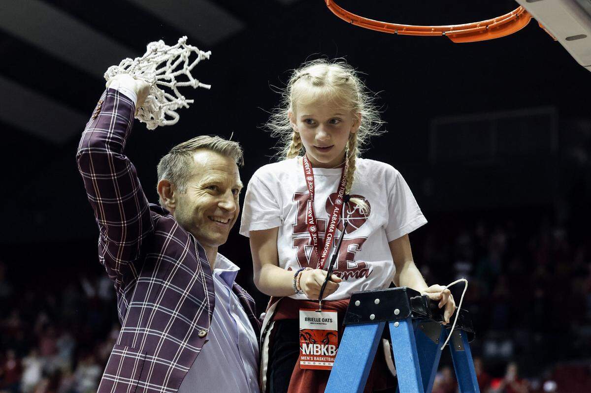 Alabama head coach Nate Oats, with daughter Brielle, celebrates after the Crimson Tide clinched the SEC regular-season title and the No. 1 seed in this week’s league tournament in Nashville.