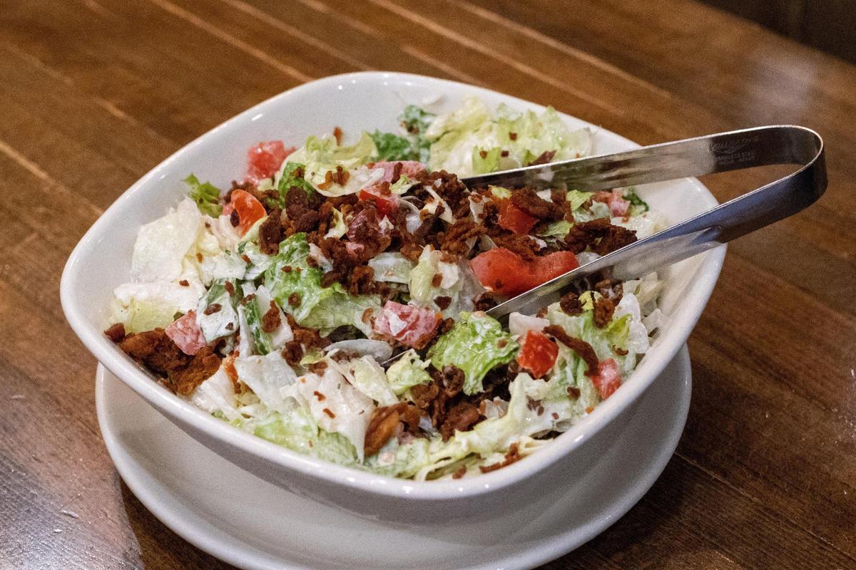 Every steak at Malone’s comes with their bottomless Lexingtonian salad. But when the restaurant first opened, they offered two A bowl of Lexingtonian salad offered another bottomless salads, the “Green Goddess.”