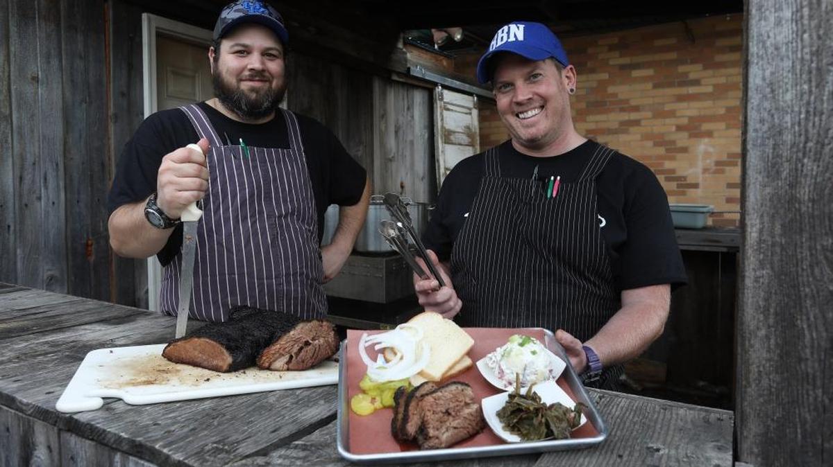 Blue Door Smokehouse co-owners Jeff Newman and Jon Rigsby, with brisket and platter in a 2017 photo. Blue Door was highlighted in a Washington Post travel piece recently.