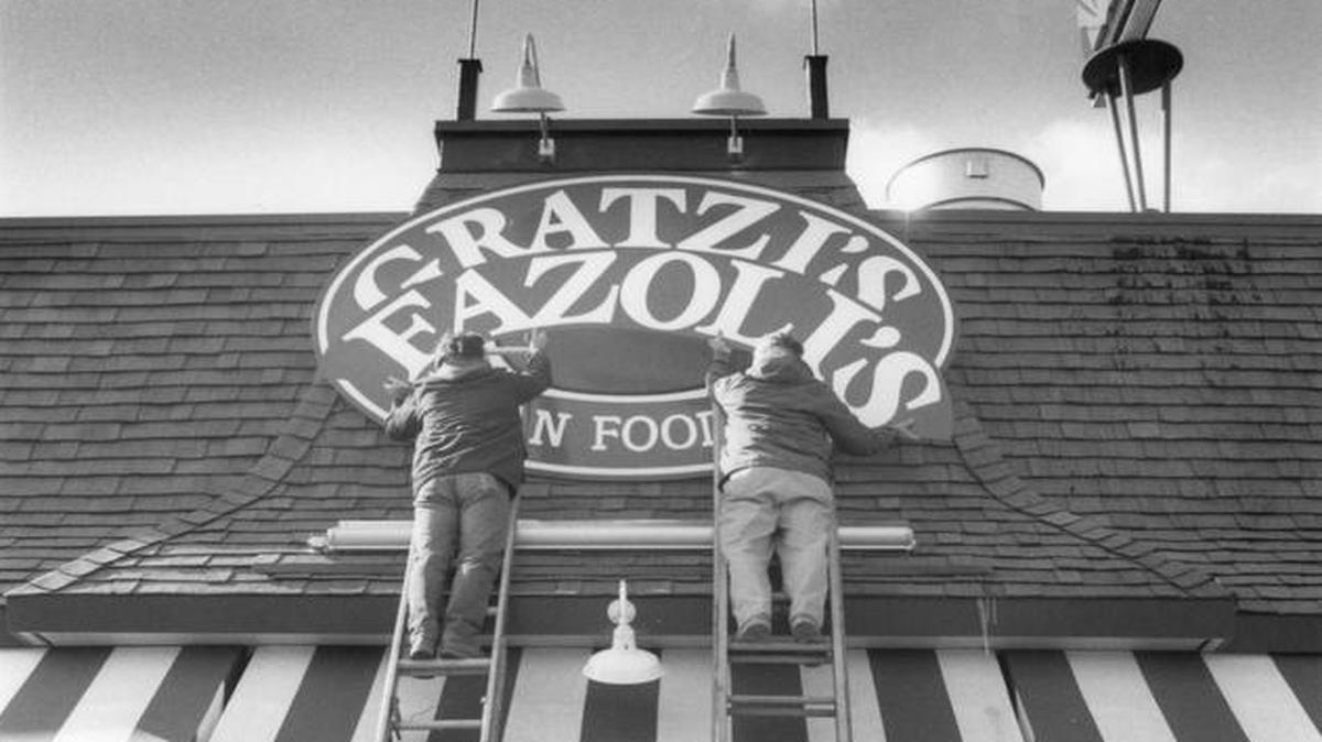 In this 1989 file photo, Martin Sherrod, left and Clint Sherrod of the Sherrod Sign Company change the sign on Gratzi’s, on North Broadway in Lexington, to it’s new name, Fazoli’s.