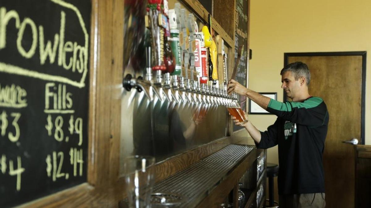 Owner Kevin Compton poured a beer for a customer at Pivot Brewing Company on Delaware Avenue in Lexington. The taproom, which opened in 2016, is for sale.