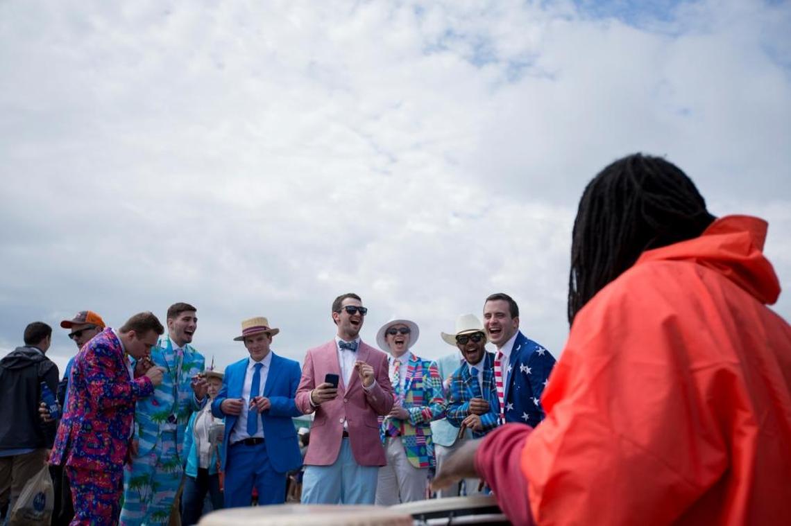 Left to right, Mitch Kaiser, Derek Humphrey, Tre Flores, Tyler Davis, Anthony Marzolf, Dominic Russ, and Tyler Flores laugh as a street performer chants poetry at everyone who passes by him during the 143rd Kentucky Derby on May 6, 2017 in the Infield at Church Hill Downs in Louisville.
