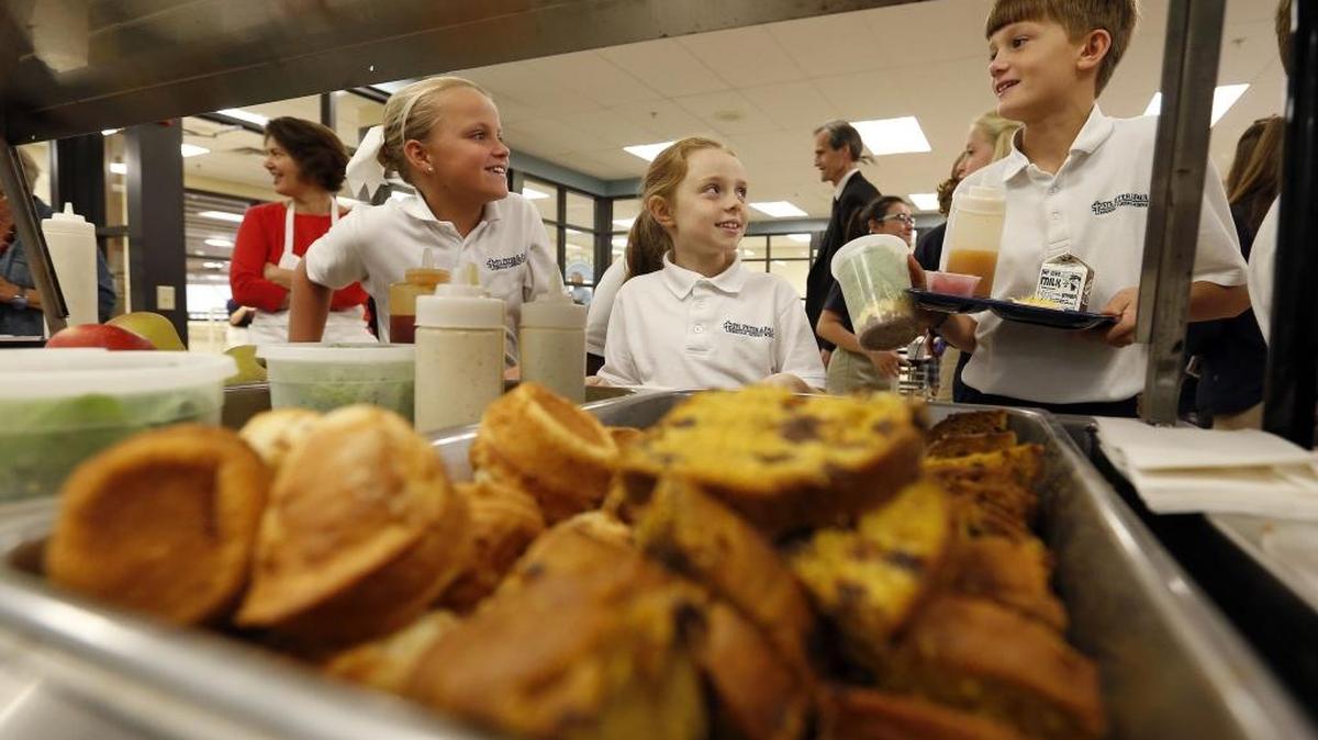 Sts. Peter and Paul Regional Catholic School students Ella Thiel, Audra Pierce and Nate Coen chose lunch from items made with ingredients for the apple cinnamon muffins came from Weisenberger in Midway and the apple pumpkin bread ingredients came from Quarles Farm, Waddy. The layered salad, served in a plastic container that Coen selected had items from at least four different Kentucky farms.