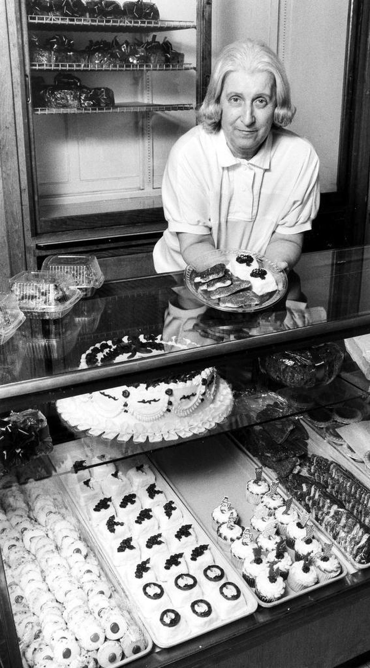 Joyce Higgins, owner of Magee’s Bakery with her husband, Ralph, displays some Christmas cookies and pettifores Dec. 6, 1990 that are being baked now for the holidays. Her cases are filled with many other homemade treats.
