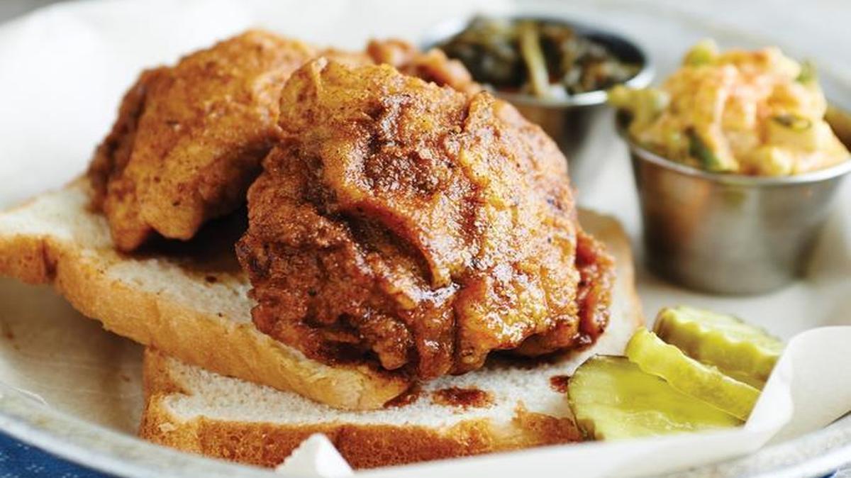 Traditional Nashville hot chicken is fried, skin on, after it is breaded and spiced with cayenne, dry mustard, paprika and garlic. Then it is dressed with a paste of the spicy rub mixed with fat, usually lard. Serve on white bread to soak up the grease, with dill pickles.