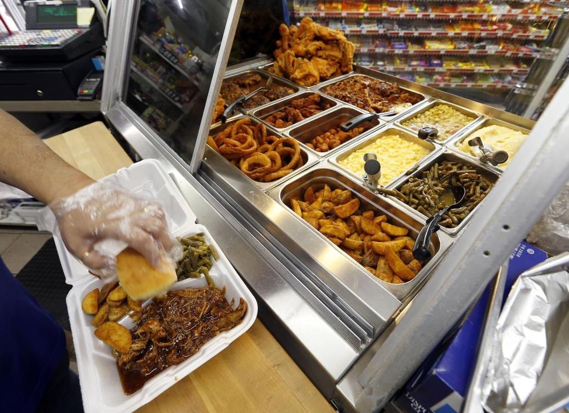 Becky Mayes prepared a plate lunch at the J&B Deli inside the J&B Food Mart in downtown Versailles.