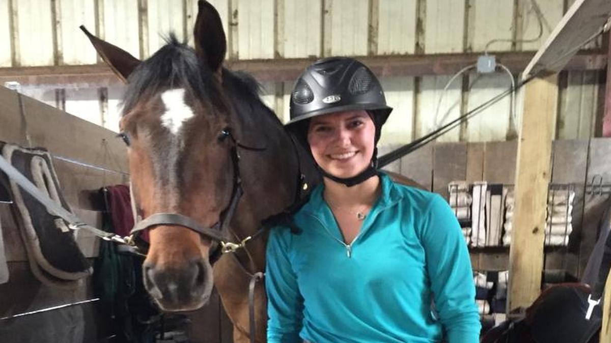 Taylor Weinold, a sophomore and accounting major stands with horse, Cassio at Robert Murphy Stables. Weinold competed in zones as the team rider for novice over fences.