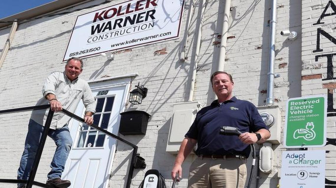 Mike Warner, left, of Koller Warner Construction and Jamie Clark of Synergy, holding a charger for an electric car, outside the building on Winchester Road.