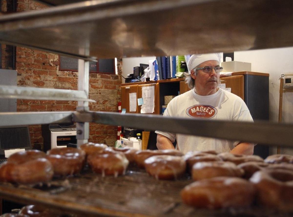 Co-owner Greg Higgins surveyed the activity on a busy morning at Magee’s Bakery on Dec. 30, 2015. He and his sister, Beverly, inherited the business from their parents, Ralph and Joyce Higgins. Greg bakes; Joyce used to decorate cakes but now focuses on counter service.