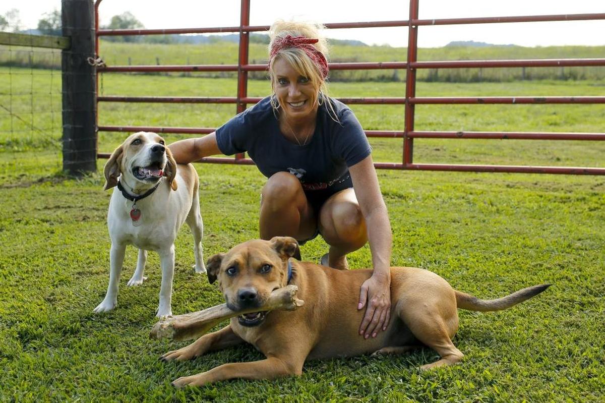 Jennifer Williams poses for a photo with Nasty and his foster sister Gypsy at Williams' home in Stanford, Ky., on Thursday, August 3, 2017.