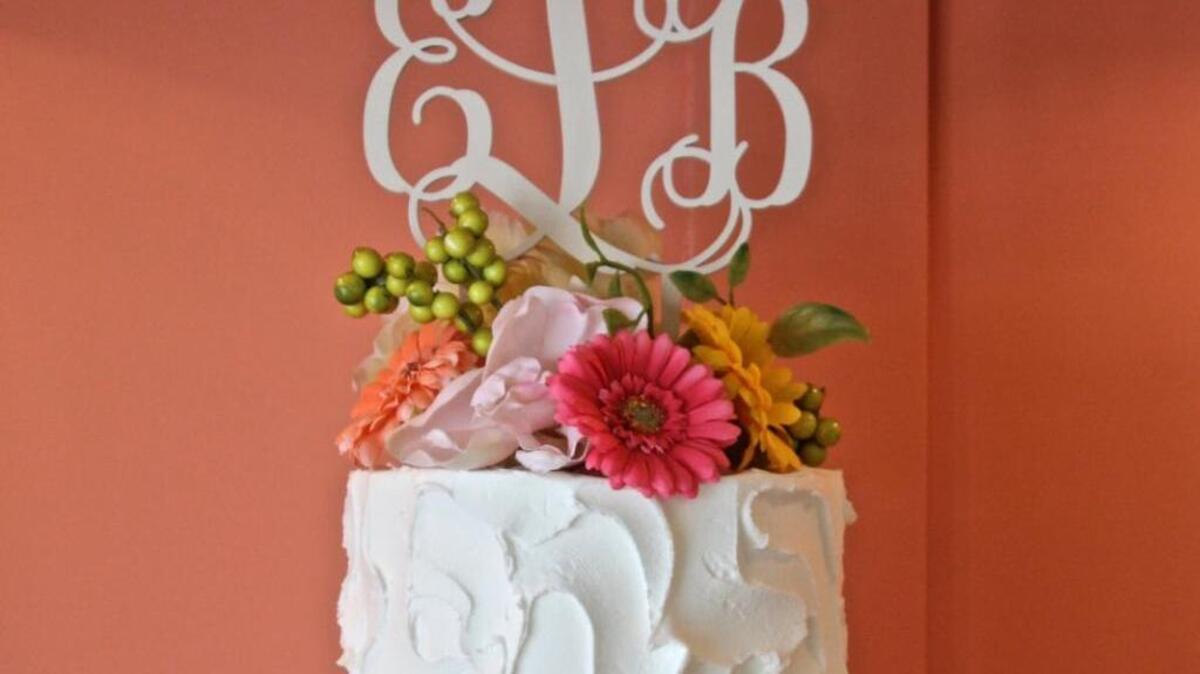 This personalized wood cake topper by Lexington-based Inscribed Monograms is $26 at Etsy.com/shop/ inscribed monograms.