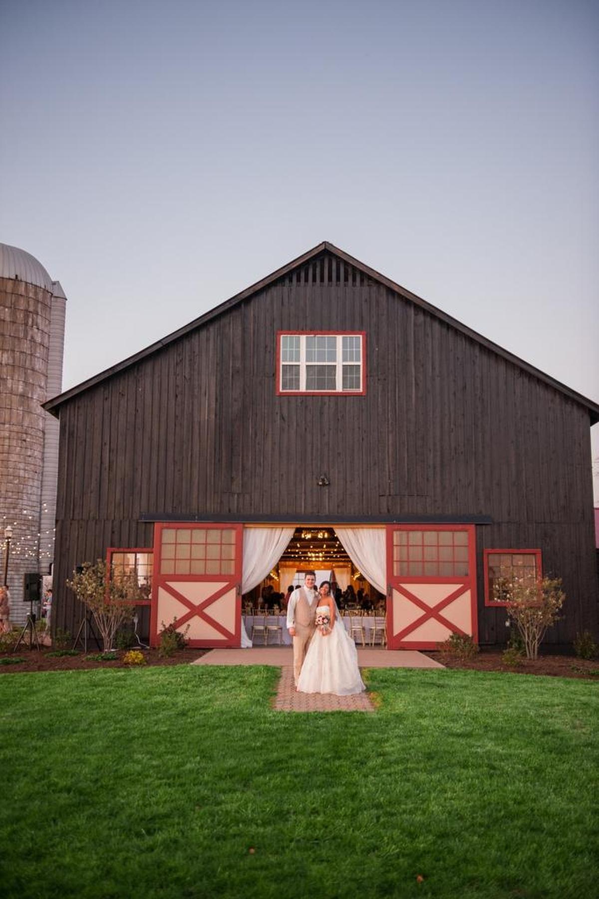 Jordan and Jacinta Roundtree in front of the barn at Evans Orchard in Georgetown.