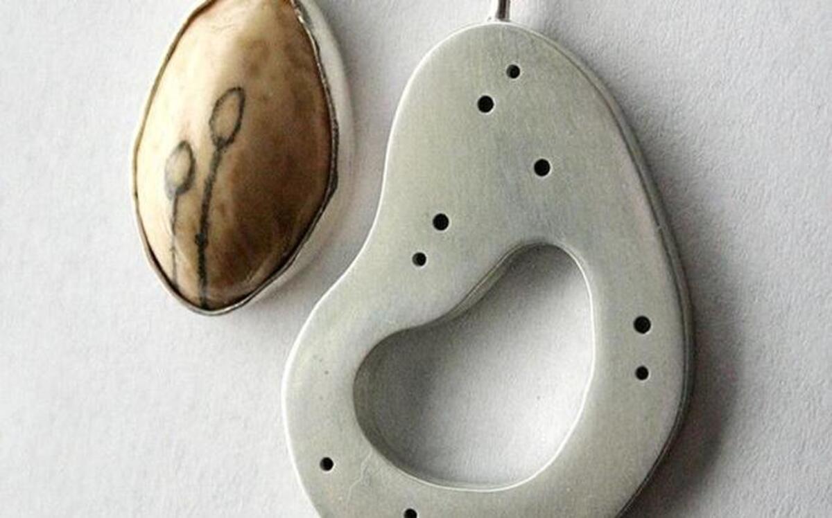 Dodie Wrocklage-Harp creates jewelry incorporating elements from nature. This necklace, $185, features a bezel-set pistachio shell with a hand-drawn design and sterling silver. Look for the artist at the Francisco’s Farm Arts Fair in Midway this weekend.