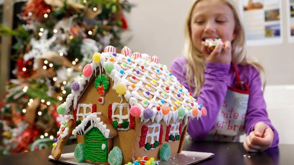 Jayda Davis, 8, the daughter of Chef Allison Davis, with a gingerbread house at Wild Thyme Cooking School on Chinoe Road in Lexington. Allison Davis teaches classes on making gingerbread houses.