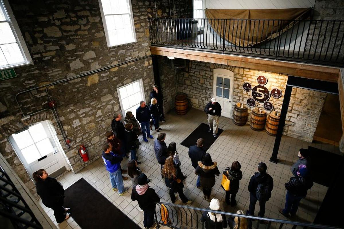 Tour guide Chuck Wolfe, of Frankfort, center, leads a group through the Woodford Reserve Distillery in Versailles in December, 2017.