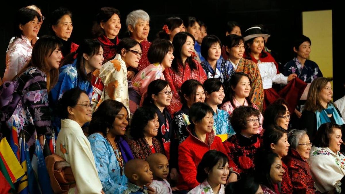 People wearing traditional clothing from their various countries posed for a photo during a Parade of Nations.
