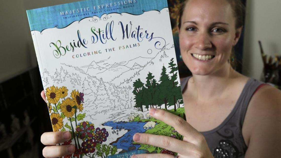 Artist Ember Canada held the coloring book she illustrated. Canada illustrated “Beside Still Waters: Coloring the Psalms” last year.