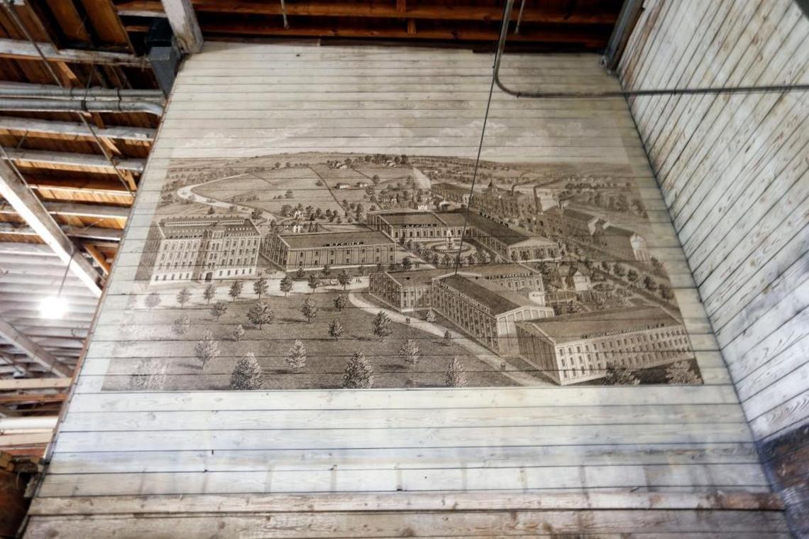 A drawing of the distilling complex has been installed on a wall at the Bourbon Pompeii at Buffalo Trace. The building is shown in the historic illustration on the right, with smoking smokestacks, along the Kentucky River.