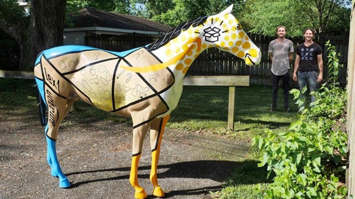 Lexington artists Jared, left, and Aaron Scales of BroCoLoco stand next to Amazon’s 15th anniversary commemorative horse statue.