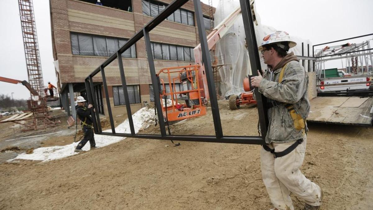 Matt Baker, left and Ashley Wright of Hek Glass prepared to install a window frame in the Stantec Building under construction at Beaumont Centre in Lexington on Jan. 26, 2016.