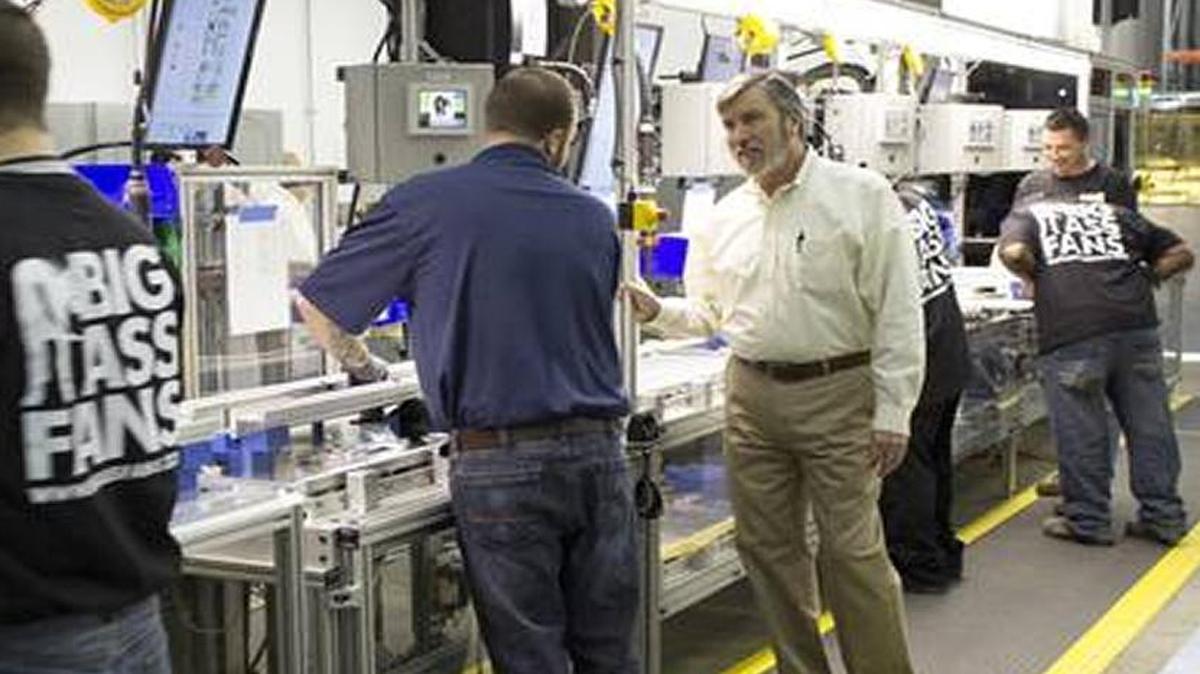 Big Ass CEO Carey Smith, right, spoke with a team leader along the company’s Big Ass High Bay LED light fixture assembly line in Lexington in 2014.