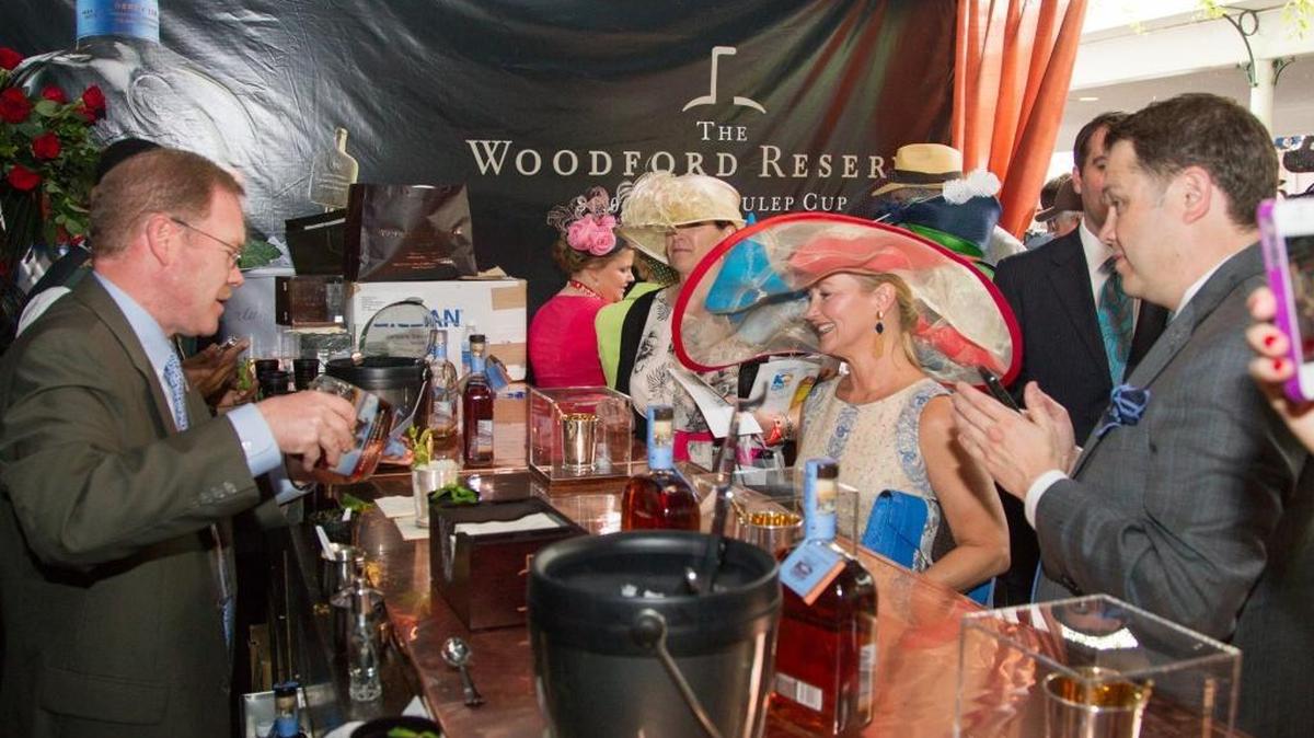 Chris Morris, Master Distiller at Woodford Reserve distillery, prepares a mint julep for Anita Cauley, right with hat, in the Brown Forman tent before the 139th running of the Kentucky Derby at Churchill Downs in Louisville, Ky. Saturday May 4, 2013. On Oct. 25, Churchill Downs announced Woodford Reserve will be the presenting sponsor of the Kentucky Derby.