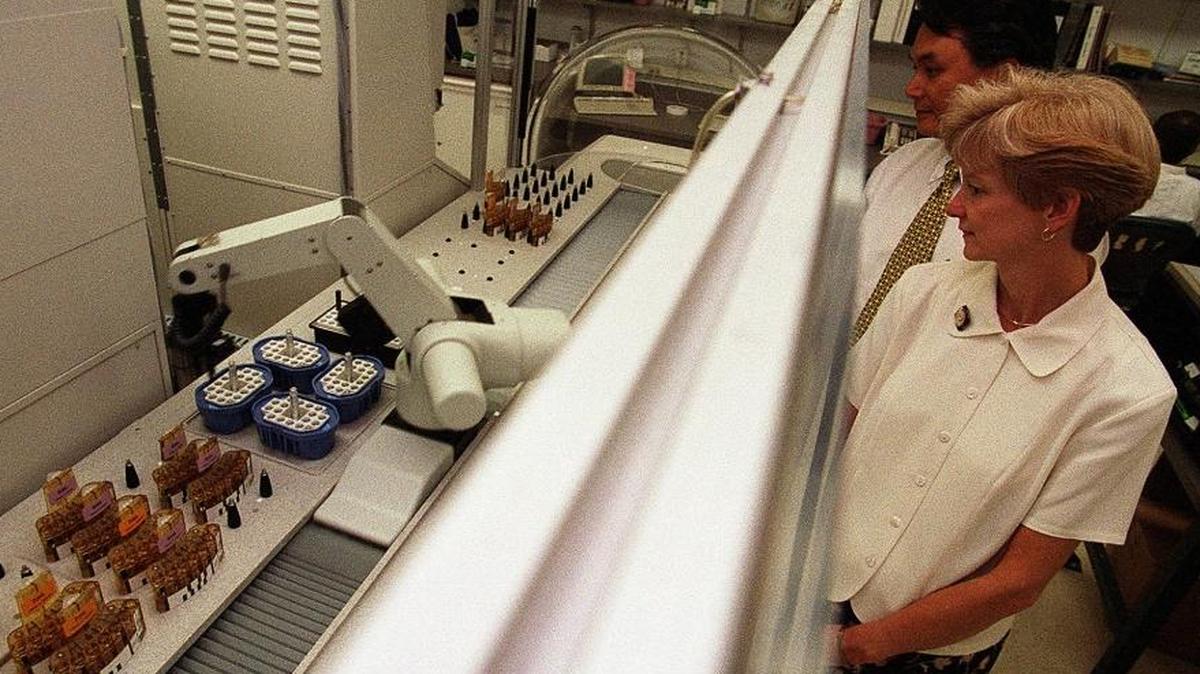 Hung T. Bui, Program Manager for Beckman Coulter and Cindy Blakemore, Manager of the Core Lab inside Loyola Medical Center's Russo Pavillion in Chicago watch a new robot system that processes blood specimens. Technology could replace up to 375 million employees worldwide by 2030, a new study predicts.