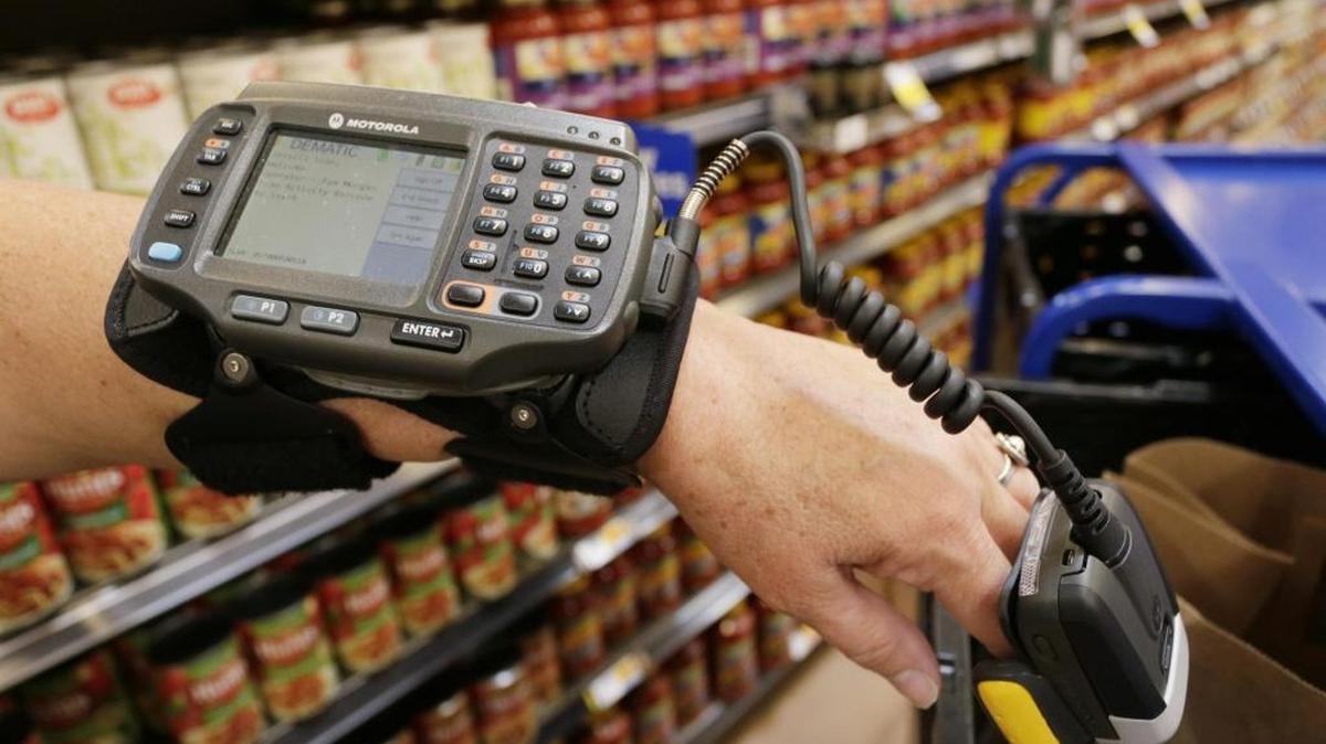 Kroger employee Pam Morgan showed a wrist-mounted device used for online shopping in August at the Kroger store in Versailles. The Versailles store was one of the first Kroger stores in the country to have online ordering. The device gives an employee a customer’s grocery list and a code for where to find the item in its specific aisle and shelf location.