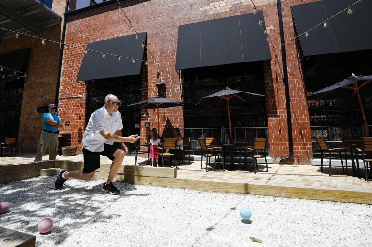 Drew Mendenhall of Lexington plays bocce with friends outside of Goodfellas Pizzeria at the Historic Pepper Distillery Campus in Lexington. The campus has been awarded the Blue Grass Trust Clyde Carpenter Award for Adaptive Reuse.