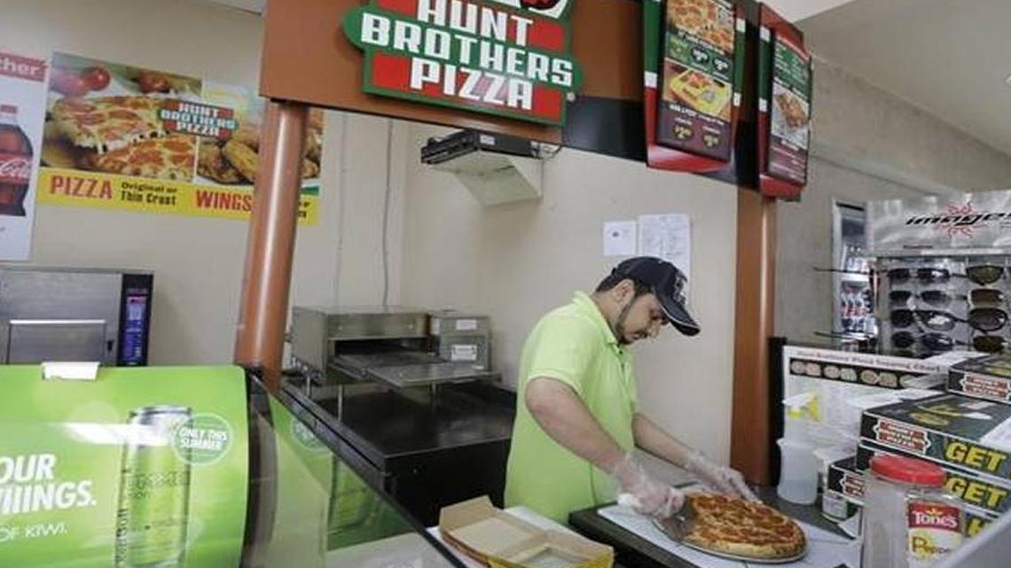 Ronak Patel prepared a Hunt Brothers pizza at Athens Food Mart in Lexington in May, 2016. Hunt Brothers pizza will be served at Rupp Arena starting this fall.