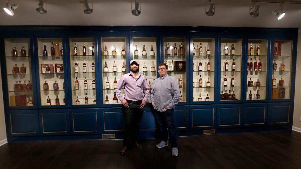 Justin Thompson, left and Justin Sloan, right, in the vintage bourbon room at their Justins’ House of Bourbon at the corner of Jefferson and West Main streets. Many of the bottles came from their personal collections.